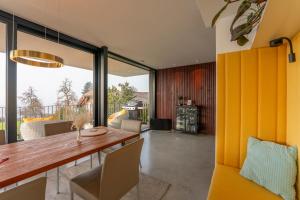 a dining room with a wooden table and chairs at ORANGE LOUNGE Attersee in Weyregg