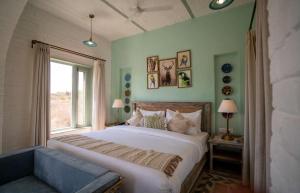 a bedroom with a large bed and a window at Kadamb Bagh-A Luxury Nature Resort Sariska in Rāmsinghpura