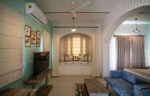 a room with a window and a blue couch at Kadamb Bagh-A Luxury Nature Resort Sariska in Rāmsinghpura