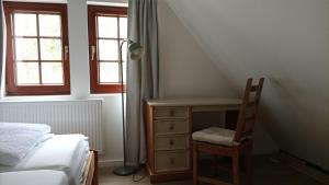 a bedroom with a desk and a bed and a chair at The Red House in Celle