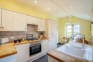 a kitchen with white cabinets and a sink at 1 Bed in Evesham oc-55177 in Bretforton