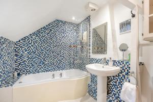 a blue and white bathroom with a tub and a sink at 1 Bed in Evesham oc-55177 in Bretforton +19 photos