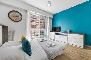 a bedroom with a bed and a clock on the wall at LE PALAIS Centre-Ville - Proche Mer Terrasse Wifi in Menton +6 photos