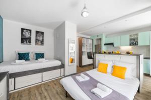 a bedroom with two beds with orange and blue pillows at LE PALAIS Centre-Ville - Proche Mer Terrasse Wifi in Menton