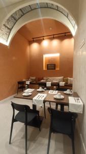 a dining room with tables and chairs and an archway at CASA DA GRAÇA in Ponta Delgada