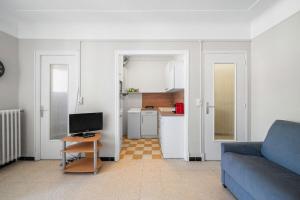 a living room with a blue couch and a kitchen at LE FELIX FAURE - Hyper Centre - Terrasse - Plages in Menton