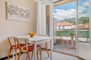 a dining room with a table and chairs and a balcony at LE FELIX FAURE - Hyper Centre - Terrasse - Plages in Menton +12 photos