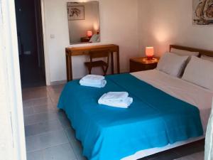 a bedroom with a bed with two towels on it at Villa Bienvenue Apartments in Kanapitsa