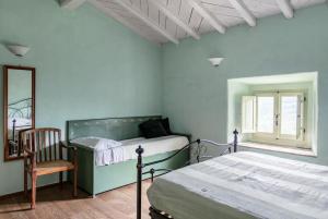 a bedroom with two beds and a chair and a mirror at Villa Toscanna in Pelago