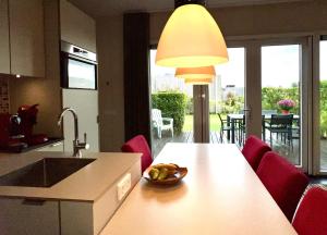 a kitchen with a table with a bowl of fruit on it at Anpektop - Ecohuisjes Terschelling in Midsland