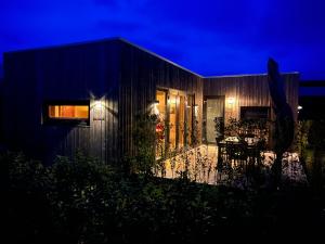 a house with a patio at night at Anpektop - Ecohuisjes Terschelling in Midsland