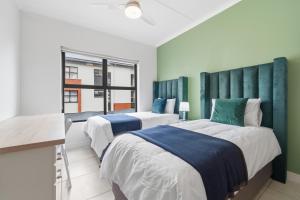 two beds in a room with green walls at Ballito Hills 171 in Ballito +29 photos