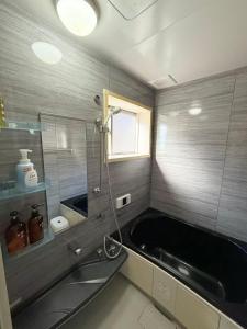 a bathroom with a black tub and a sink at 十五夜 in Osaka