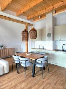 a kitchen and dining room with a wooden table and chairs at Apartamenty K17 Stare Miasto in Malbork