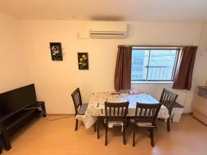 a dining room with a table and chairs and a piano at 十五夜 in Osaka