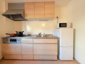 a small kitchen with a sink and a refrigerator at 十五夜 in Osaka