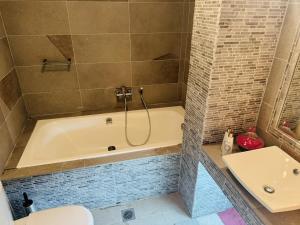 a bathroom with a tub and a toilet and a sink at Villa Bienvenue Apartments in Kanapitsa +29 photos