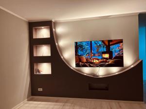 a living room with a flat screen tv on a wall at City View Apartment in Mitrovica