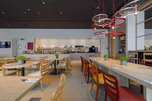 a restaurant with tables and chairs and a kitchen at IntercityHotel Herford in Herford