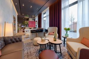 a living room with a couch and chairs and tables at IntercityHotel Herford in Herford