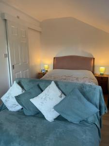 a bedroom with a bed with pillows on it at The Orchard Cabin in Cardington