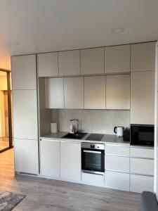 a kitchen with white cabinets and a stove at Kaunas City Center Apartment in Kaunas