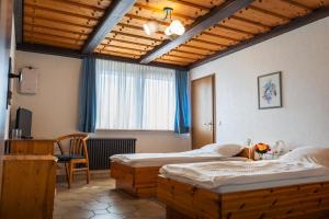 a bedroom with two beds and a table and a window at Hotel Garni Zielinski in Sindelfingen