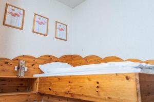 a bedroom with a wooden bed with a wooden headboard at Hotel Garni Zielinski in Sindelfingen