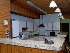 a kitchen with white cabinets and a clock on the wall at Hotel Garni Zielinski in Sindelfingen