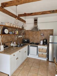 a kitchen with white cabinets and a refrigerator at Guest House Luca in Galda de Jos +2 photos