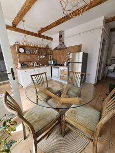 a kitchen with a glass table and two chairs at Guest House Luca in Galda de Jos