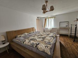 a bedroom with a large bed with a wooden frame at Guest House Luca in Galda de Jos