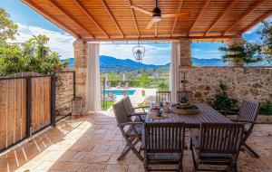 a patio with a table with chairs and a ceiling fan at Marcora Historic Mansion in Strongylí