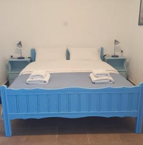 a blue bed with towels on it in a room at Babis & Popi Rooms and Studios in Frangokastello