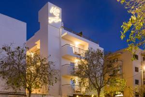 a white building with a lit up sign on it at Malacosta A - MC Apartments Ibiza in Ibiza Town