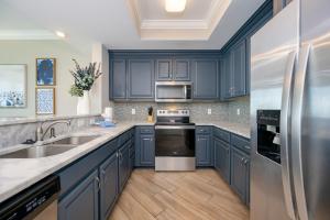 a kitchen with blue cabinets and stainless steel appliances at Phoenix Orange Beach II 2103 in Orange Beach