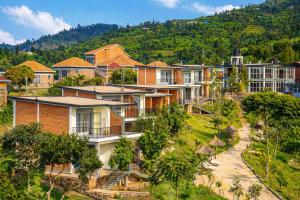 a group of houses on a hill with trees at Kaliba Beach - Rutsiro in Rutsiro