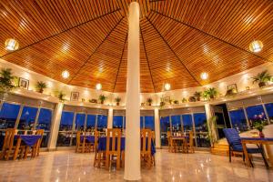 a restaurant with blue chairs and tables and windows at Kaliba Beach - Rutsiro in Rutsiro