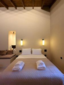 a bedroom with a bed with two towels on it at Alfa25 in Oitylo