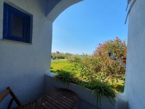 a porch with a bench and a view of a field at Babis & Popi Rooms and Studios in Frangokastello
