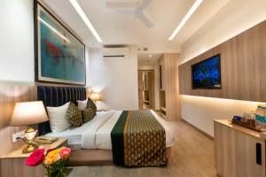 a hotel room with a bed and a tv at OPO Premier Ro'yal Delhi Airport - FREE Airport Pickup Or Drop in New Delhi +20 photos