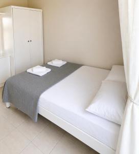 a white bed with two white towels on it at E&M Villa Sea View in Polychrono