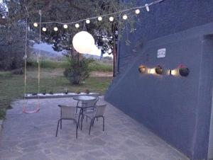 a table and chairs on a patio at night at Vesper Rooms in Skala Prinou
