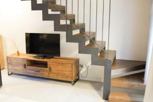 a living room with a tv and a staircase at Hillside House Sant'Andrea in Vittorio Veneto