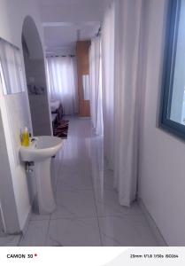 a white bathroom with a sink and a mirror at Homly Stays in Kisii
