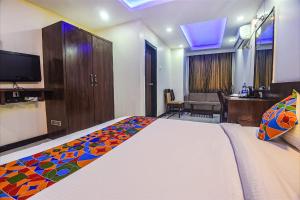 a hotel room with a bed and a desk at Hotel Shakti Palace in Ponda