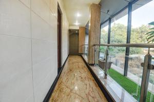 an empty hallway with wood floors and large windows at Hotel Shakti Palace in Ponda