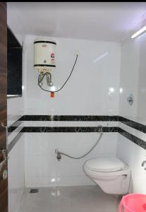 a bathroom with a toilet and a camera on the wall at zoz mount abu in Jāmb +21 photos