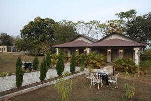 a house with a table and chairs in front of it at Tuli Orchid - A Boutique Eco Resort in Rāmtek