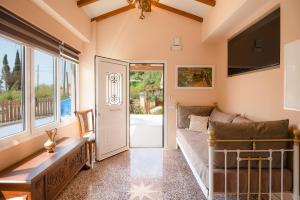 a living room with a couch and a large window at Villa Kadith Agios Gordios in Agios Gordios